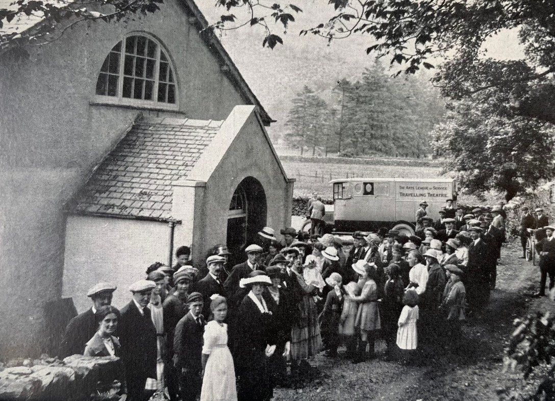 A black and white photograph of a crowd gathered outside a village hall in 1922
